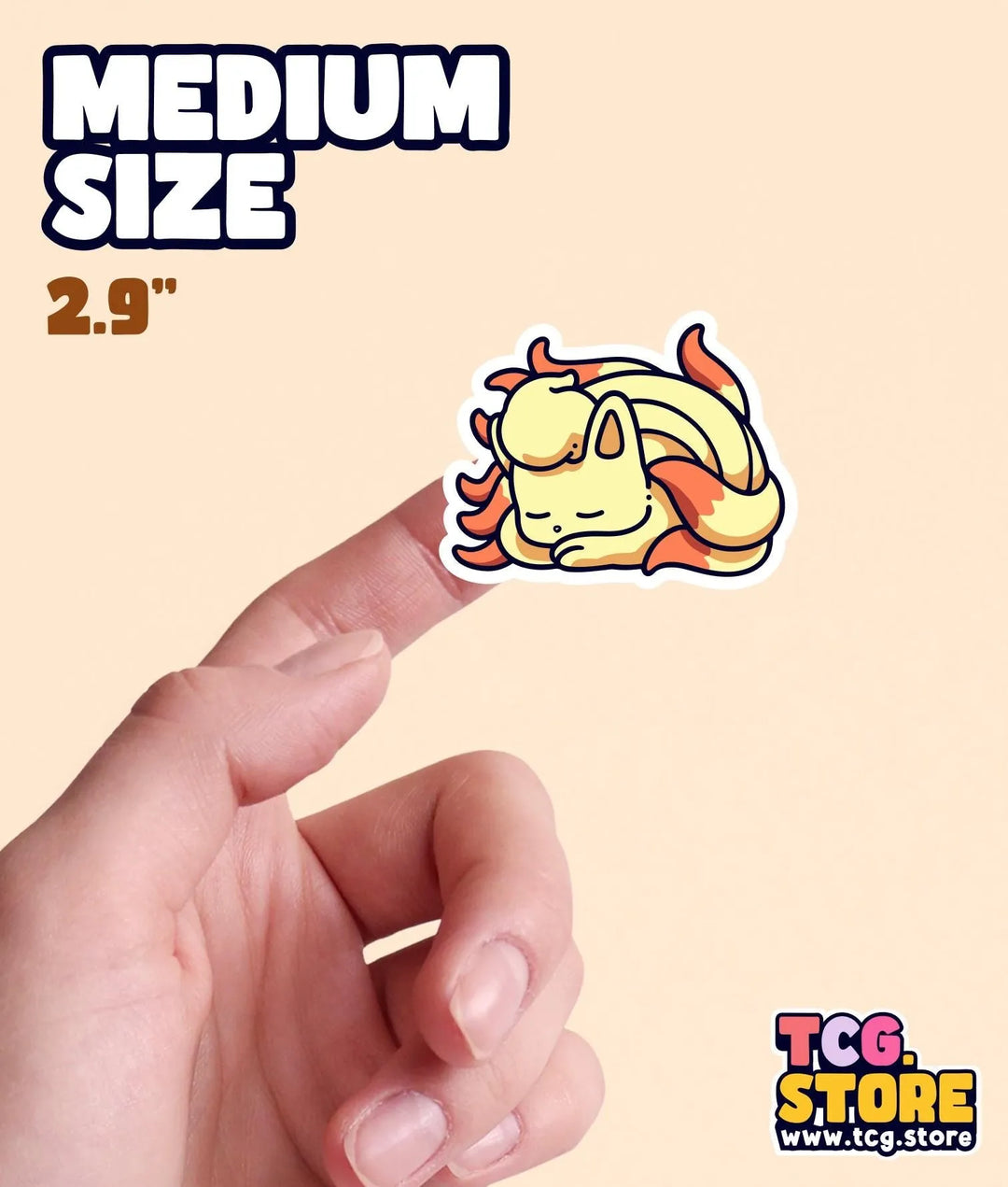 a hand holding a small sticker of a cartoon character