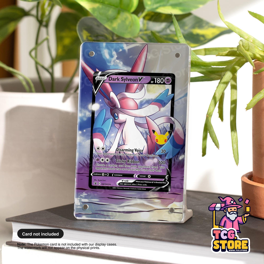 a Pokémon card display stand with a Pokémon card on it, placed on a table next to a potted plant.