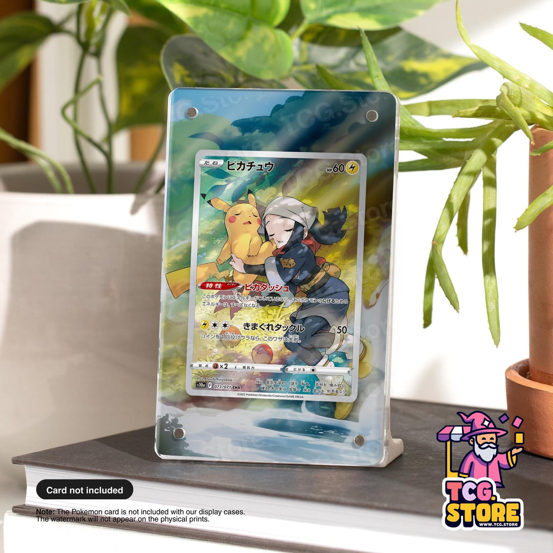 A Pokémon card display case featuring a Pokémon card with a female character and a male Pokémon, placed on a table with a potted plant in the background.