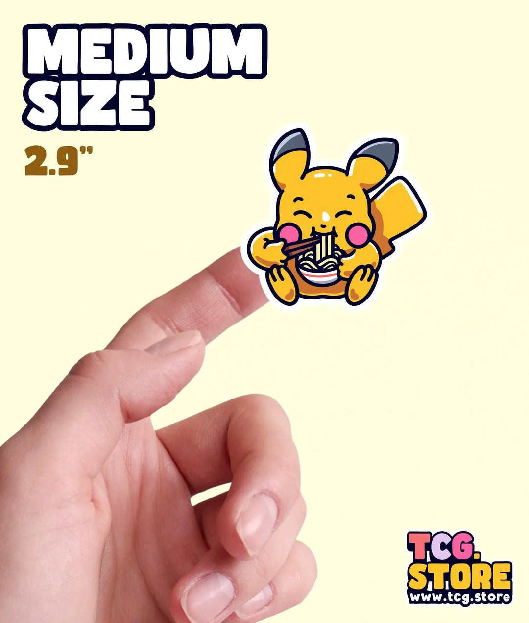 a hand holding a small sticker of a cartoon character