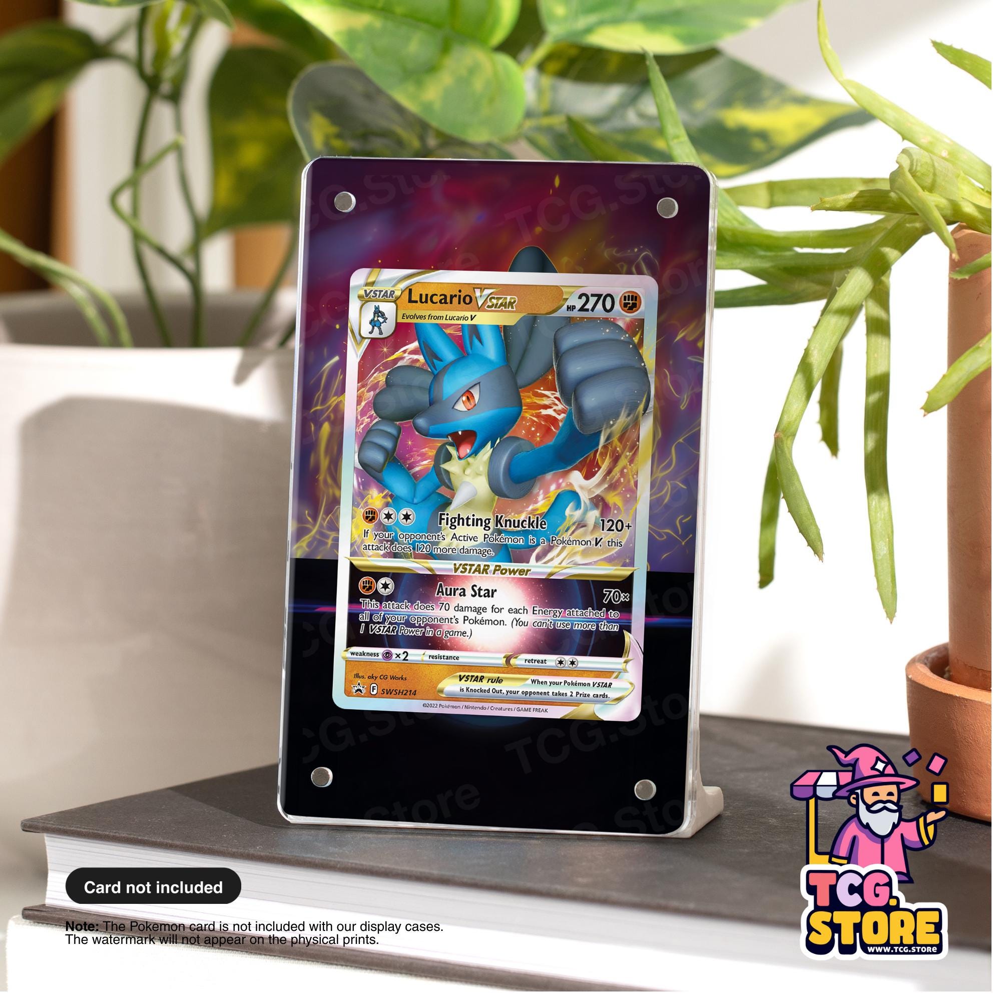 A framed Pokémon card featuring a blue and red Pokémon character is displayed on a table, with a potted plant in the background.